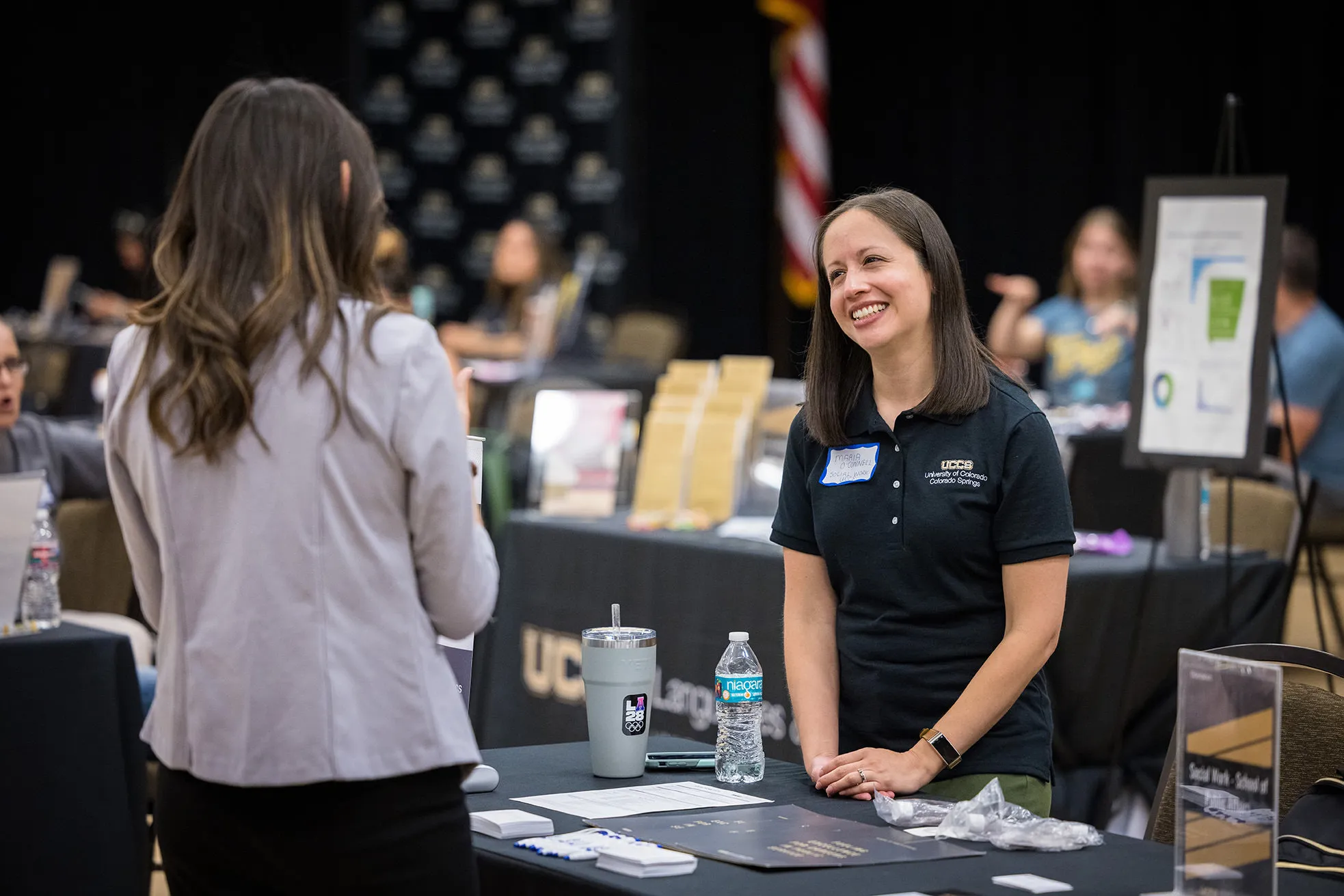 Staff member smiling at person during a tabling event.